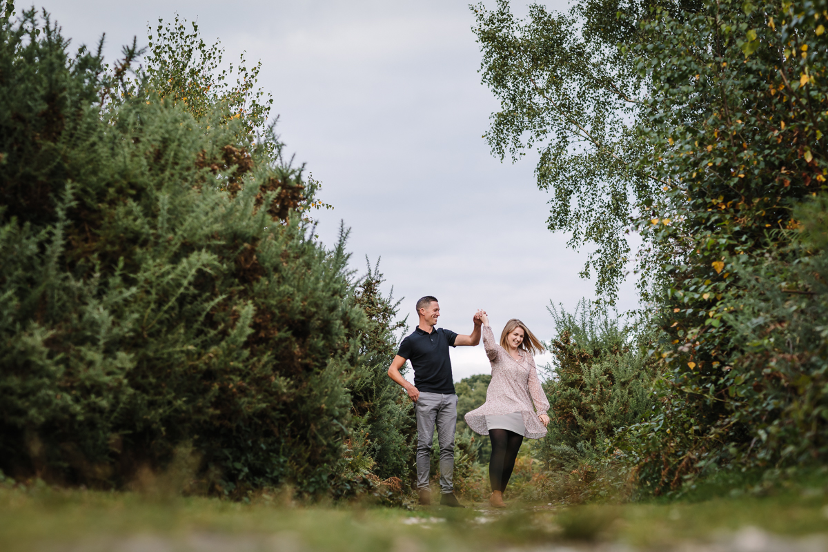 natural authentic image couple walking headily heath surrey hills twirl unposed engagement session outdoor pre-wedding_shoot natural light documentary wedding photographer