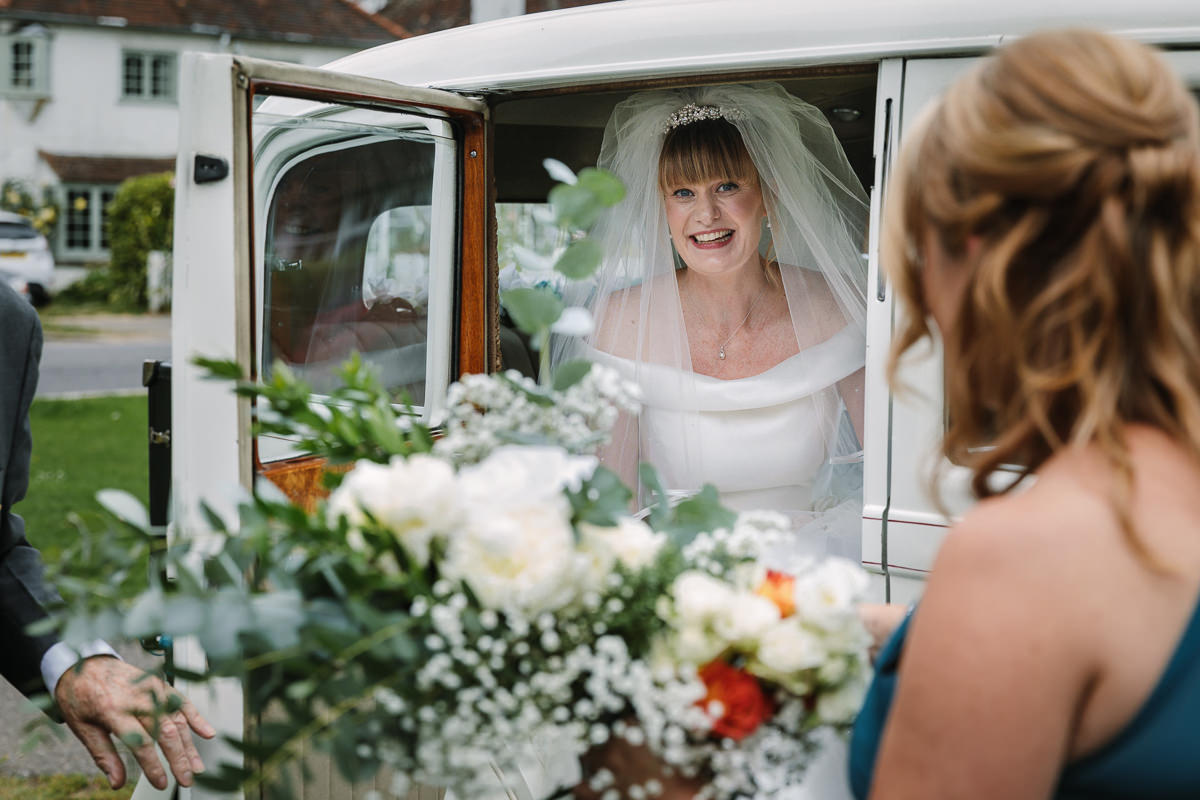 bride arrives at brockham christ church wedding ceremony bride groom surrey natural and authentic wedding portraits by documentary wedding photographer surrey and sussex