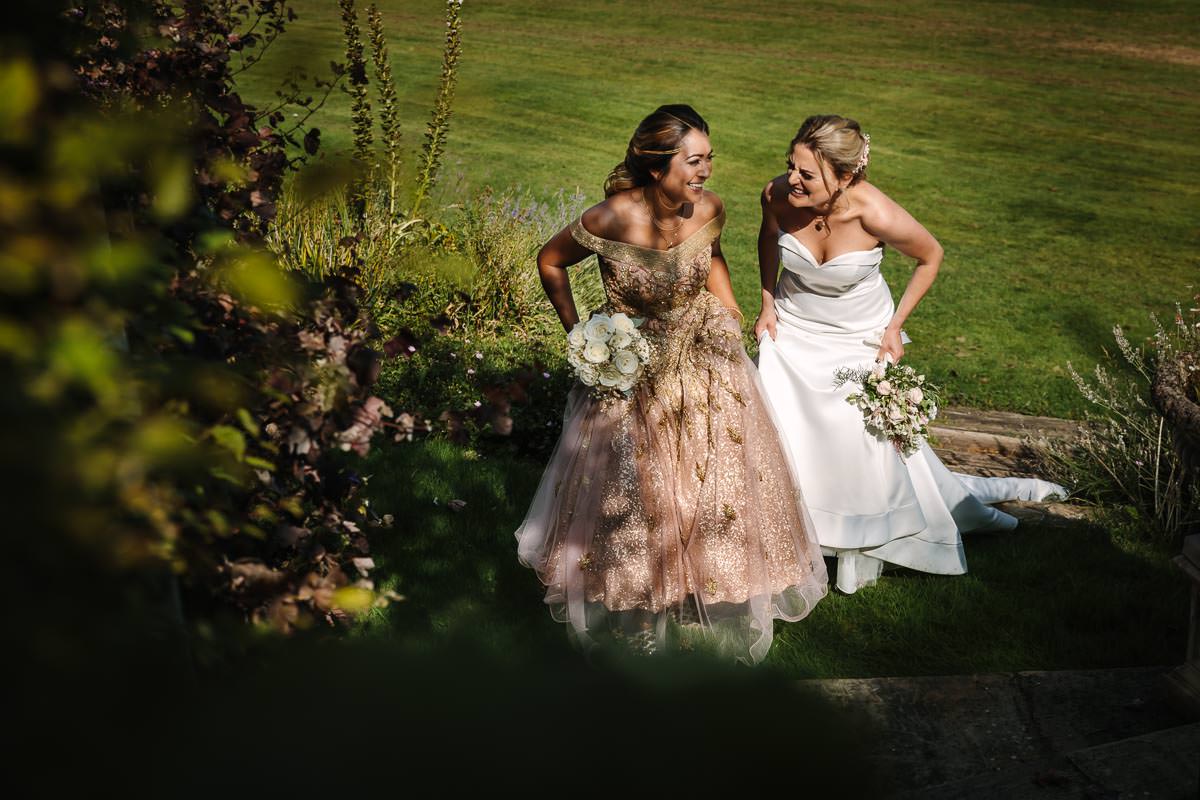  lesbian wedding couple walking during portrait session at lgbtq friendly outdoor wedding venue russets country house surrey for same_sex_wedding and natural authentic wedding portraits by documentary wedding photographer