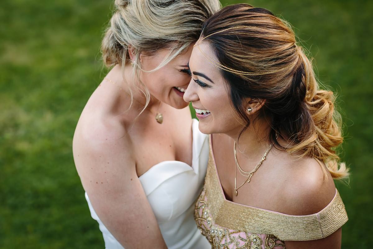 informal high-angle image of lesbian wedding couple walking during portrait session at lgbtq friendly outdoor wedding venue russets country house surrey for same_sex_wedding and natural authentic wedding portraits by documentary wedding photographer