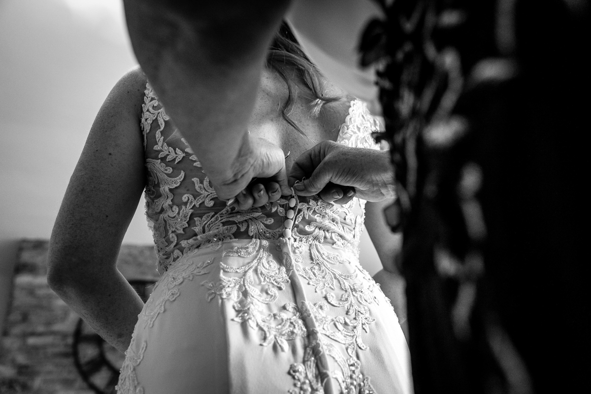 detail back of wedding dress bridal prep on wedding day black_white image natural authentic documentary wedding photo photographer surrey sussex