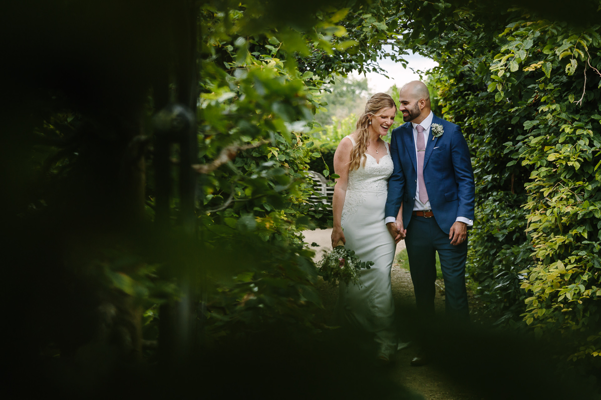 bride groom wedding couple walking during portrait session at leatherhead register office surrey for natural authentic wedding portraits by documentary wedding photographer