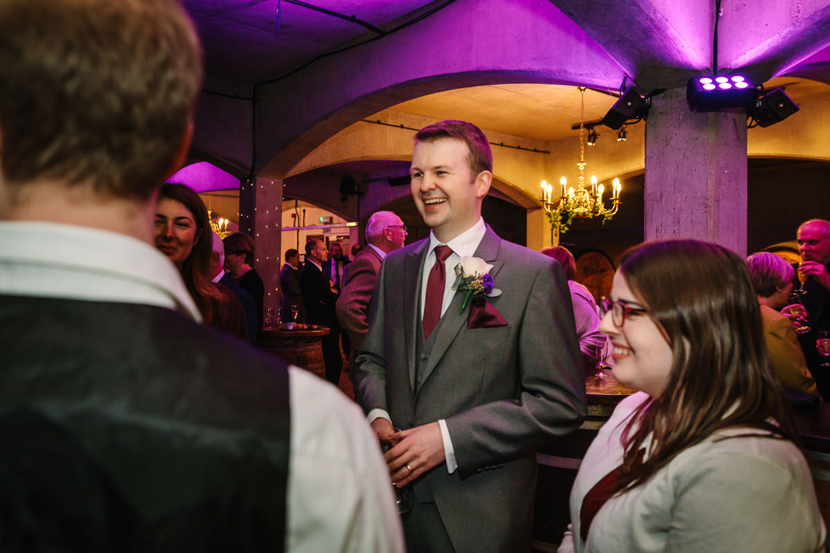 wedding reception in wine cellar at denbies vineyard dorking by documentary wedding photographer surrey for natural colourful and authentic wedding photography