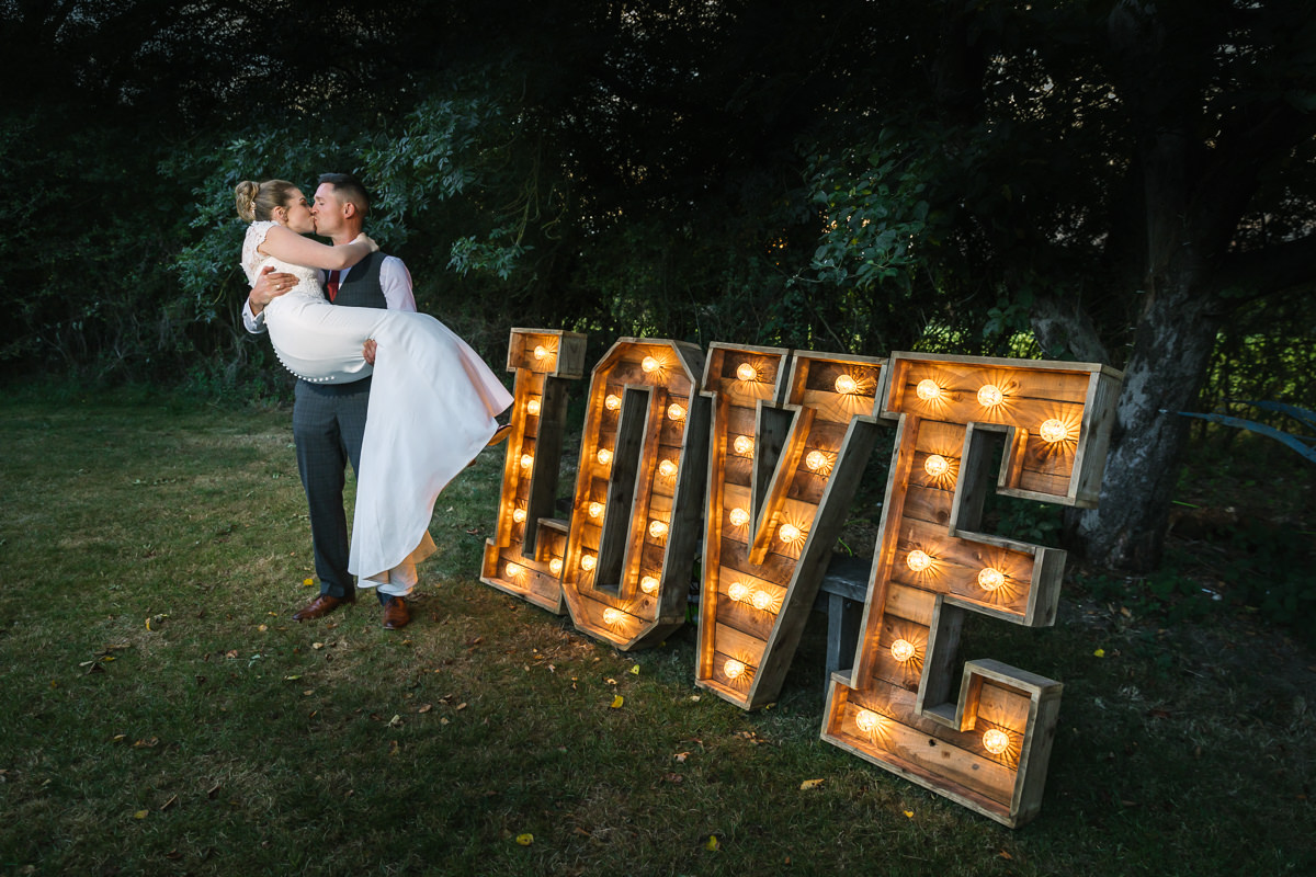 love sign with lights for wedding by lgbtq_friendly documentary wedding photographer surrey for natural candid colourful authentic unposed wedding photography