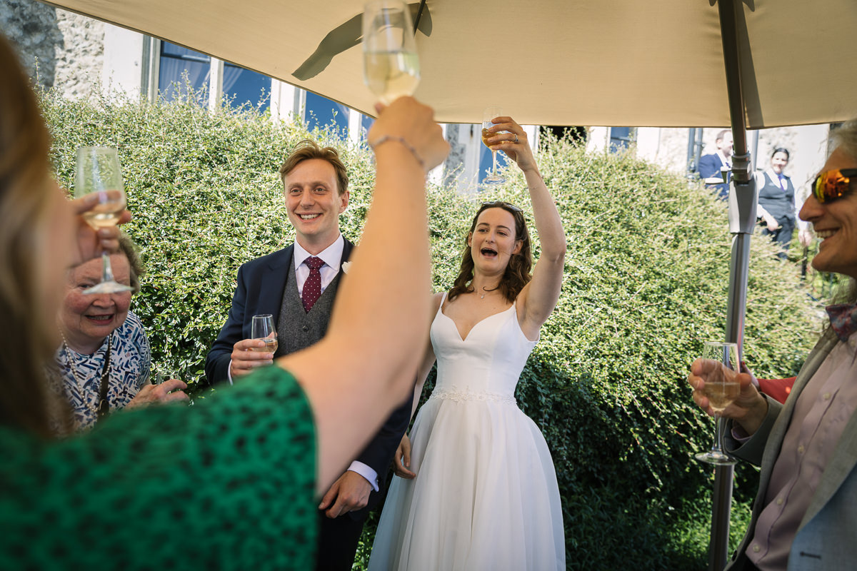 Bride and groom wedding reception toast at nutfield_priory Redhill Surrey by lgbtq_friendly documentary wedding photographer surrey Sussex for natural candid colourful authentic unposed relaxed wedding photography