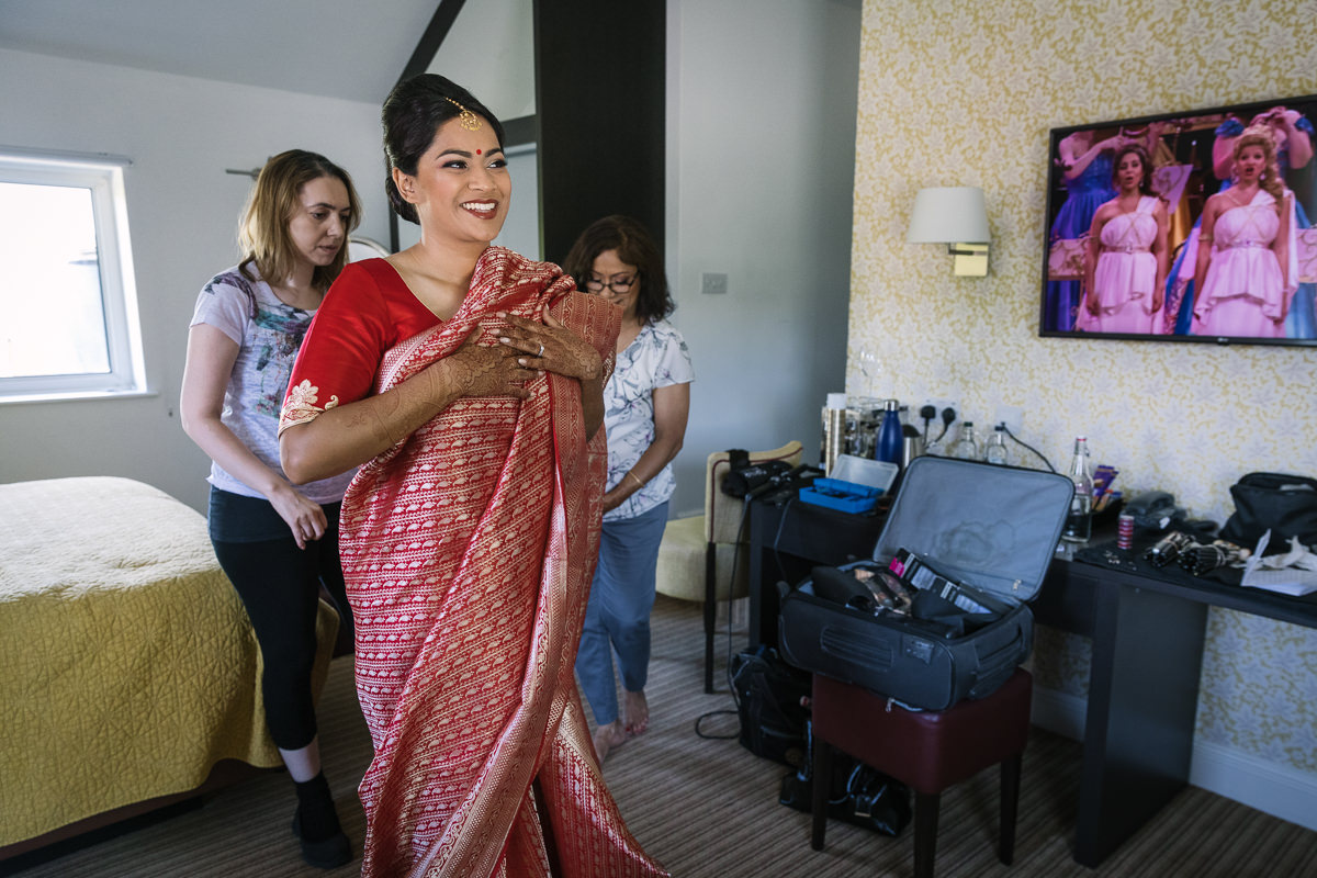 mother_of_the_bride helping indian bride getting ready for fusion wedding at denbies vineyard wedding photography by documentary wedding_photographer surrey for natural candid colourful authentic unposed relaxed images