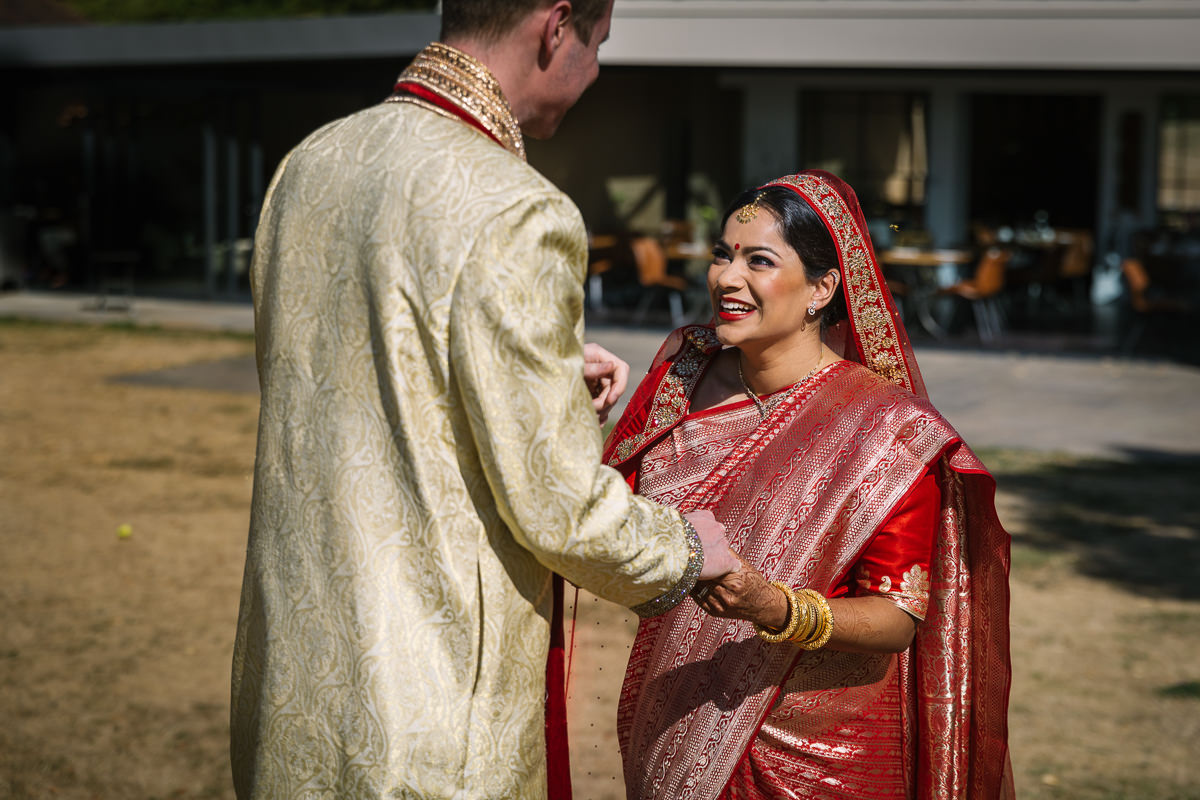 outdoor sunny first_look of indian bride and english groom fusion wedding at denbies vineyard wedding photography by documentary wedding_photographer surrey for natural candid colourful authentic unposed relaxed images