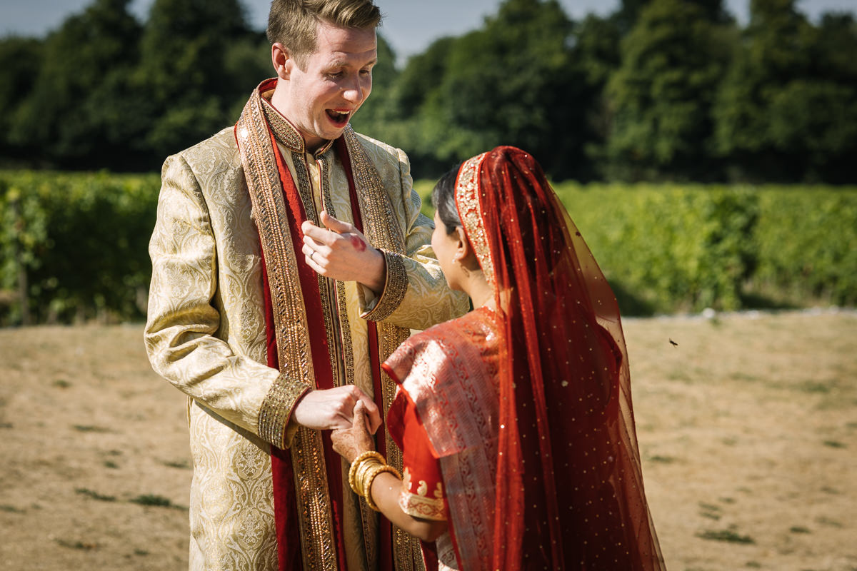 outdoor sunny first_look of indian bride and english groom fusion wedding at denbies vineyard wedding photography by documentary wedding_photographer surrey for natural candid colourful authentic unposed relaxed images