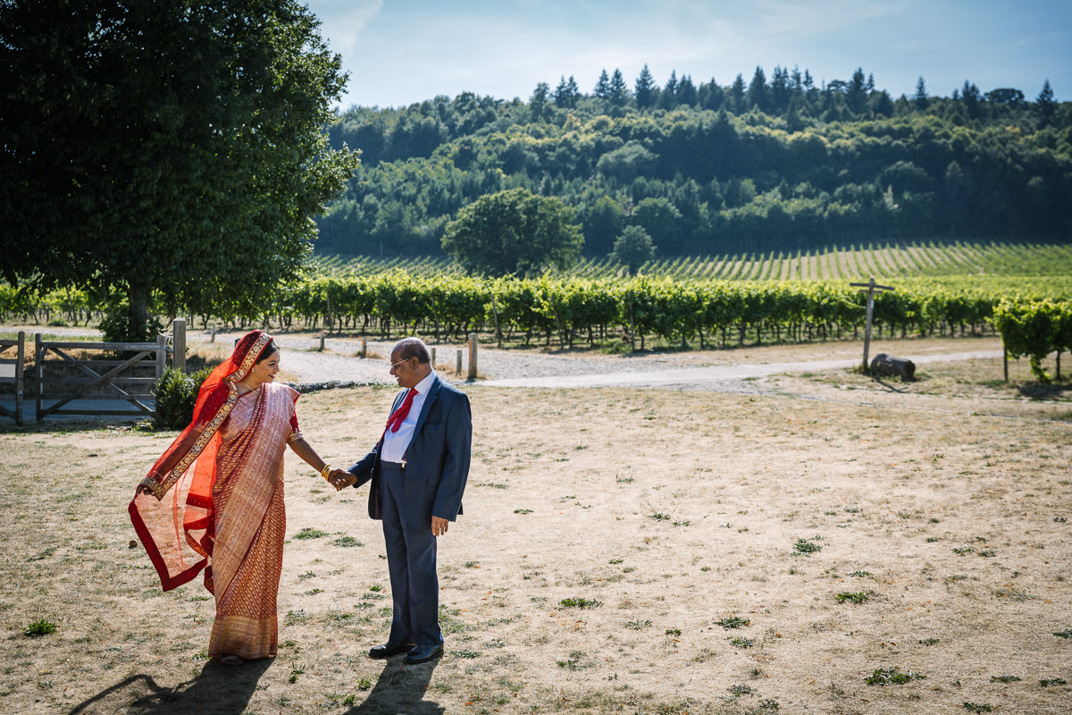 outdoor sunny first_look of indian bride and father_of_the_bride fusion wedding at denbies vineyard wedding photography by documentary wedding_photographer surrey for natural candid colourful authentic unposed relaxed images