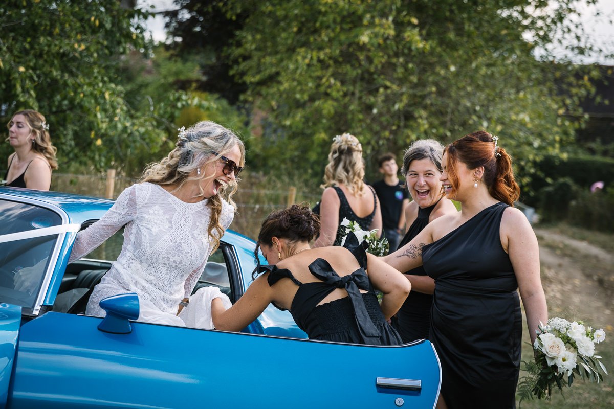 bride arrives for ceremony at outdoor tipi wedding dorking surrey by documentary wedding photographer sussex for candid natural unposed authentic LGBTQ_friendly documentary photography