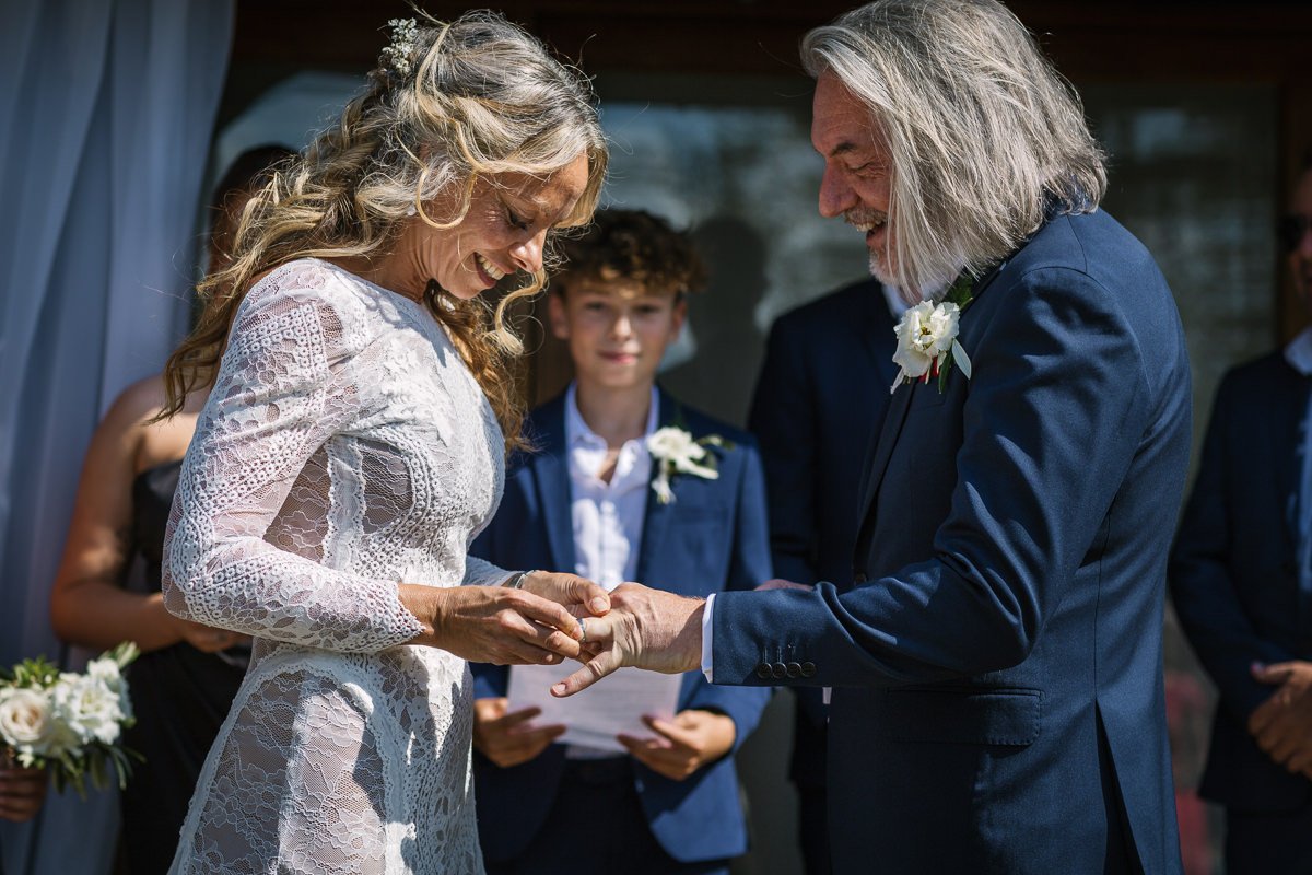 bride and groom exchange of rings during wedding ceremony at outdoor tipi wedding dorking surrey by documentary wedding photographer sussex for candid natural unposed authentic LGBTQ_friendly documentary photography
