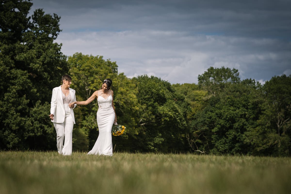 brides walking outdoor couple portrait for same_sex gay wedding at gildings_barns with natural unposed candid photography by LGBTQ friendly wedding photographer surrey sussex