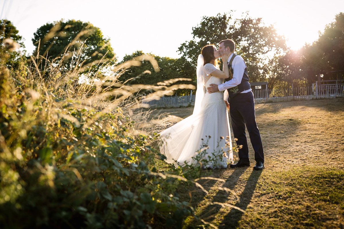golden_hour bride groom outdoor wedding portrait at barn wedding venue kent the_plough_at_leigh by documentary wedding photographer surrey sussex for natural colourful and authentic LGBTQ_friendly wedding photography