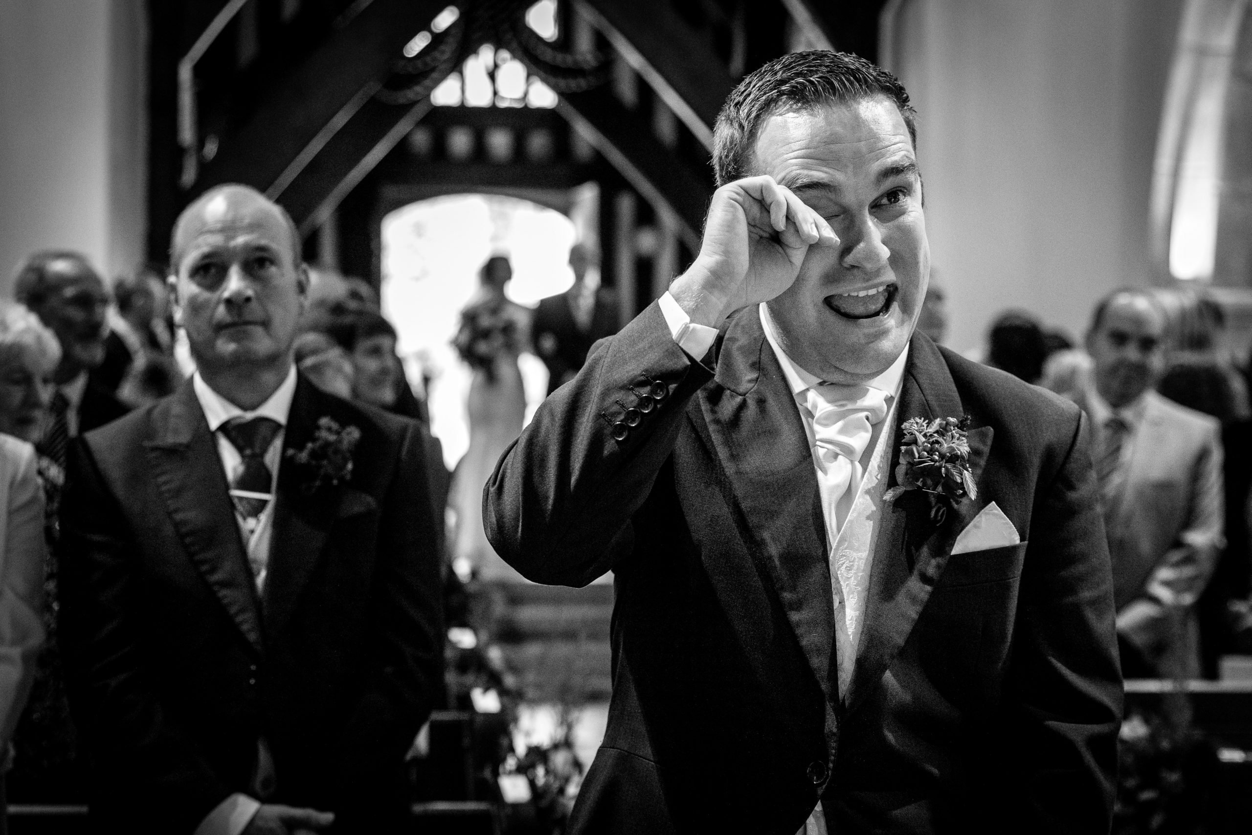 emotional groom at church just before bride comes in with father in newdigate natural unposed candid wedding photography by LGBTQ_friendly documentary wedding photographer surrey sussex