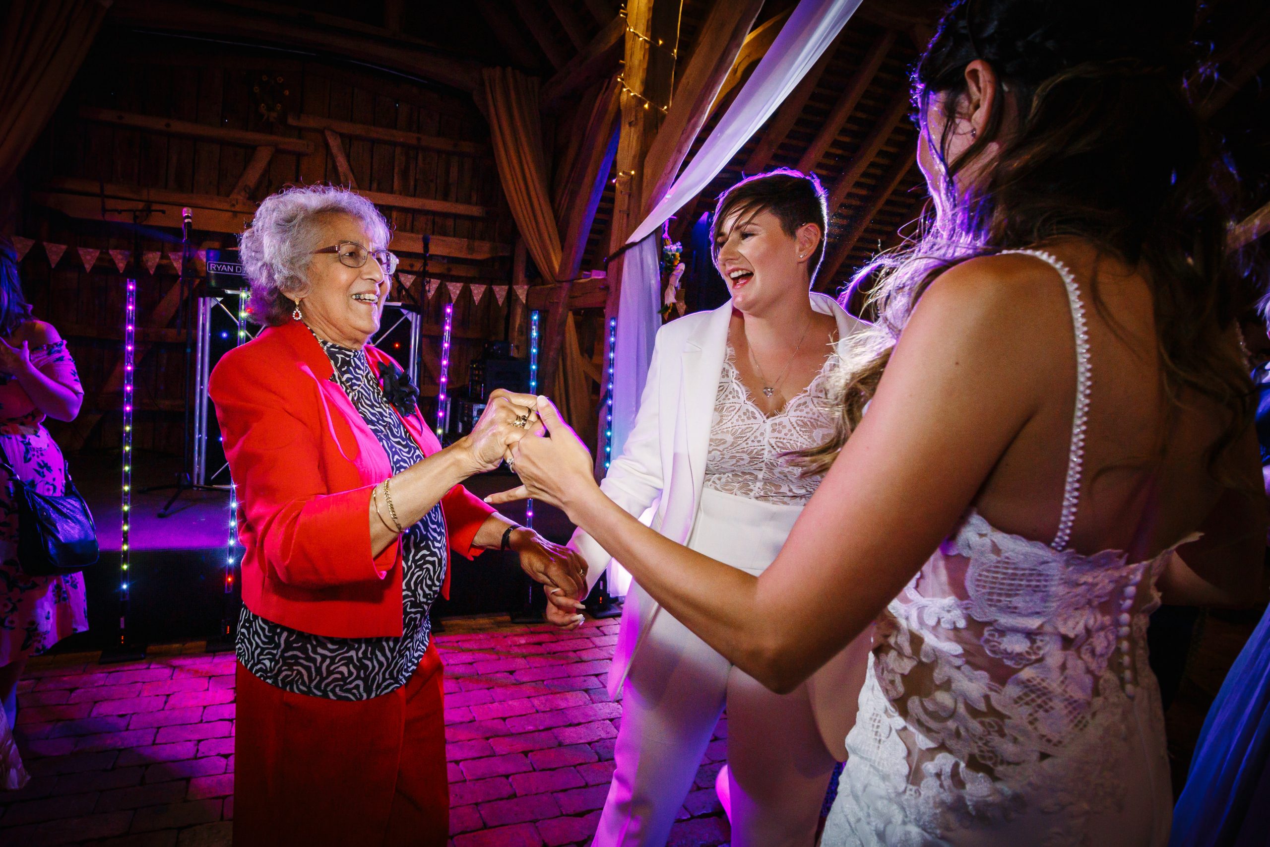 LGBTQ wedding party brides dancing with nan at gildings barns newdigate natural unposed candid wedding photography by LGBTQ_friendly documentary wedding photographer surrey sussex