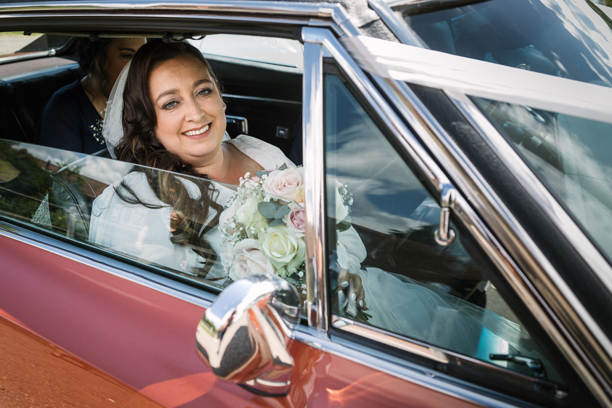 bride portrait arriving in wedding car relaxed gildings_barns wedding photography by documentary wedding photographer surrey sussex