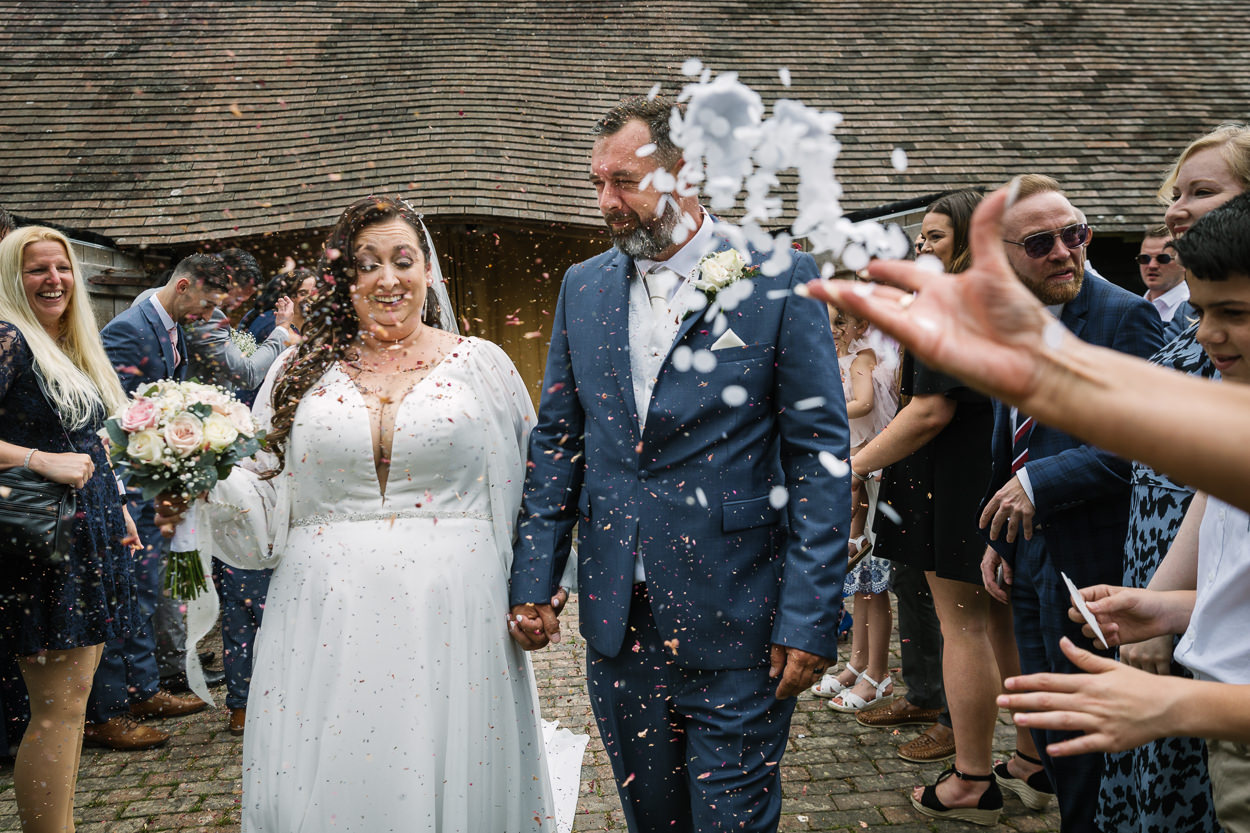 outdoor confetti throw for bride and groom after wedding ceremony relaxed gildings_barns wedding photography by documentary wedding photographer surrey sussex
