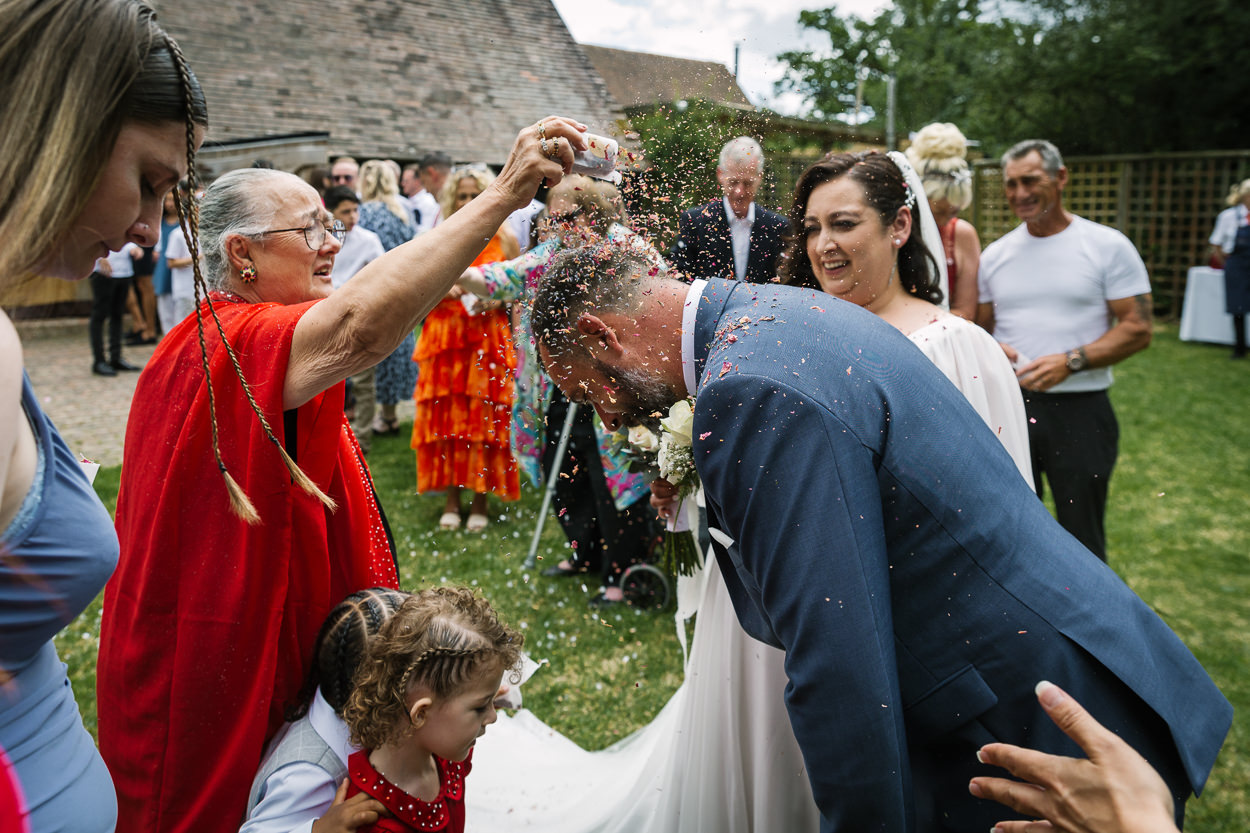 extra outdoor confetti throw for bride and groom after wedding ceremony relaxed gildings_barns wedding photography by documentary wedding photographer surrey sussex