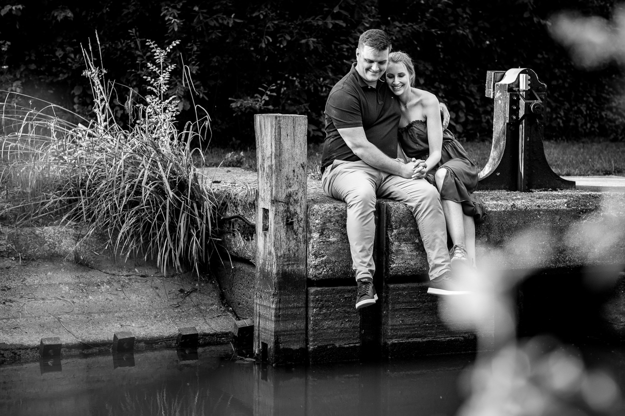 Couple enjoying the water's edge and smiling, black and white image candid engagement_shoot relaxed Pre_wedding_shoot sussex surrey by documentary wedding photographer