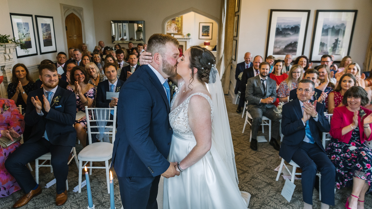 bride and groom kissing during wedding ceremony at Hartsfield_Manor_wedding Surrey by documentary wedding photographer surrey for candid natural unposed authentic documentary photography