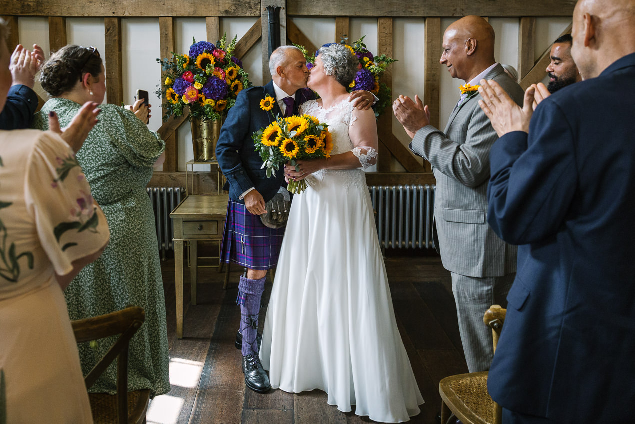 first kiss at the end of wedding ceremony at gate_street_barn wedding storytelling wedding photography by documentary wedding photographer surrey sussex