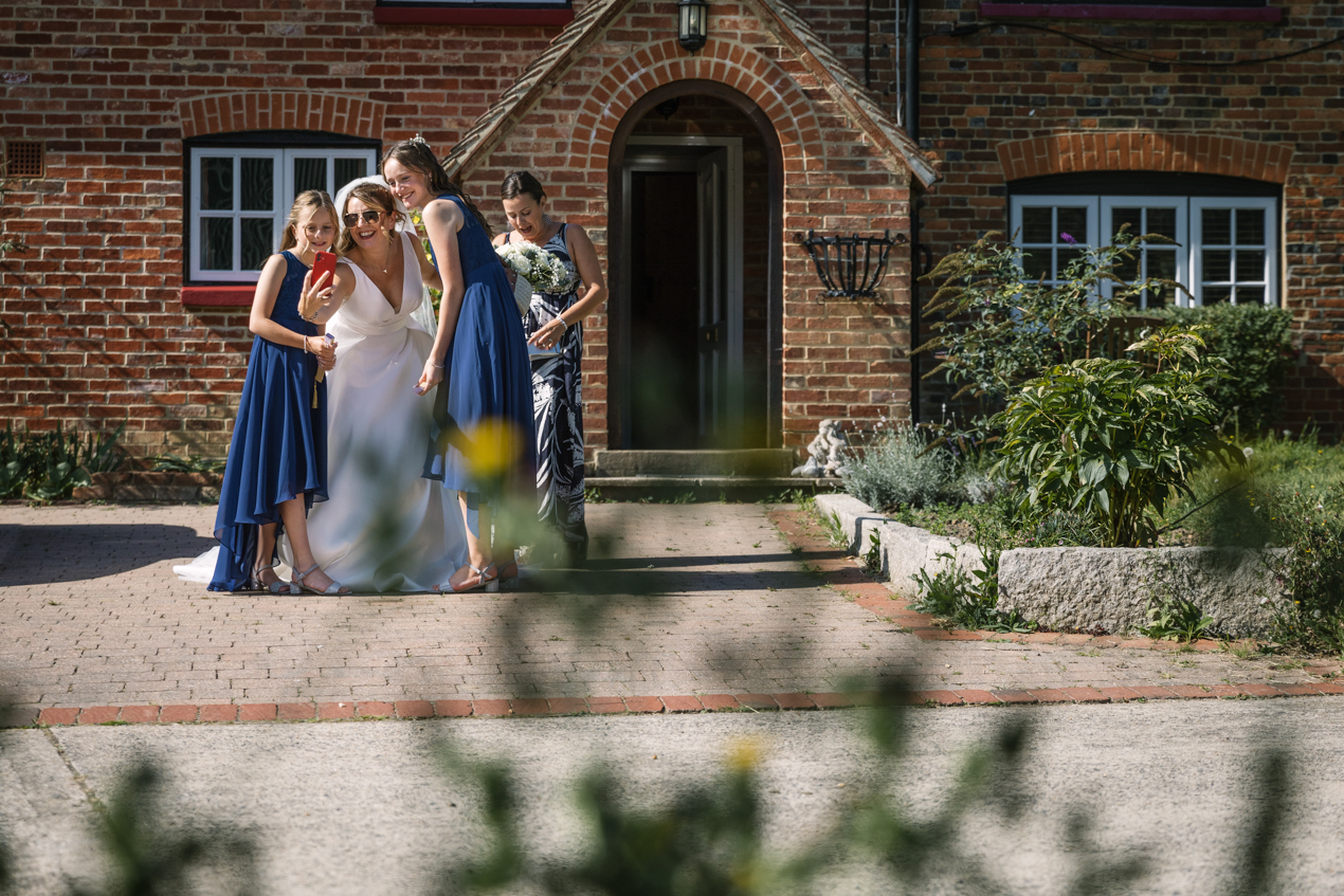 group selfie of bride and her posse just before leaving fr wedding venue candid gildings_barns wedding photography by documentary wedding photographer surrey sussex