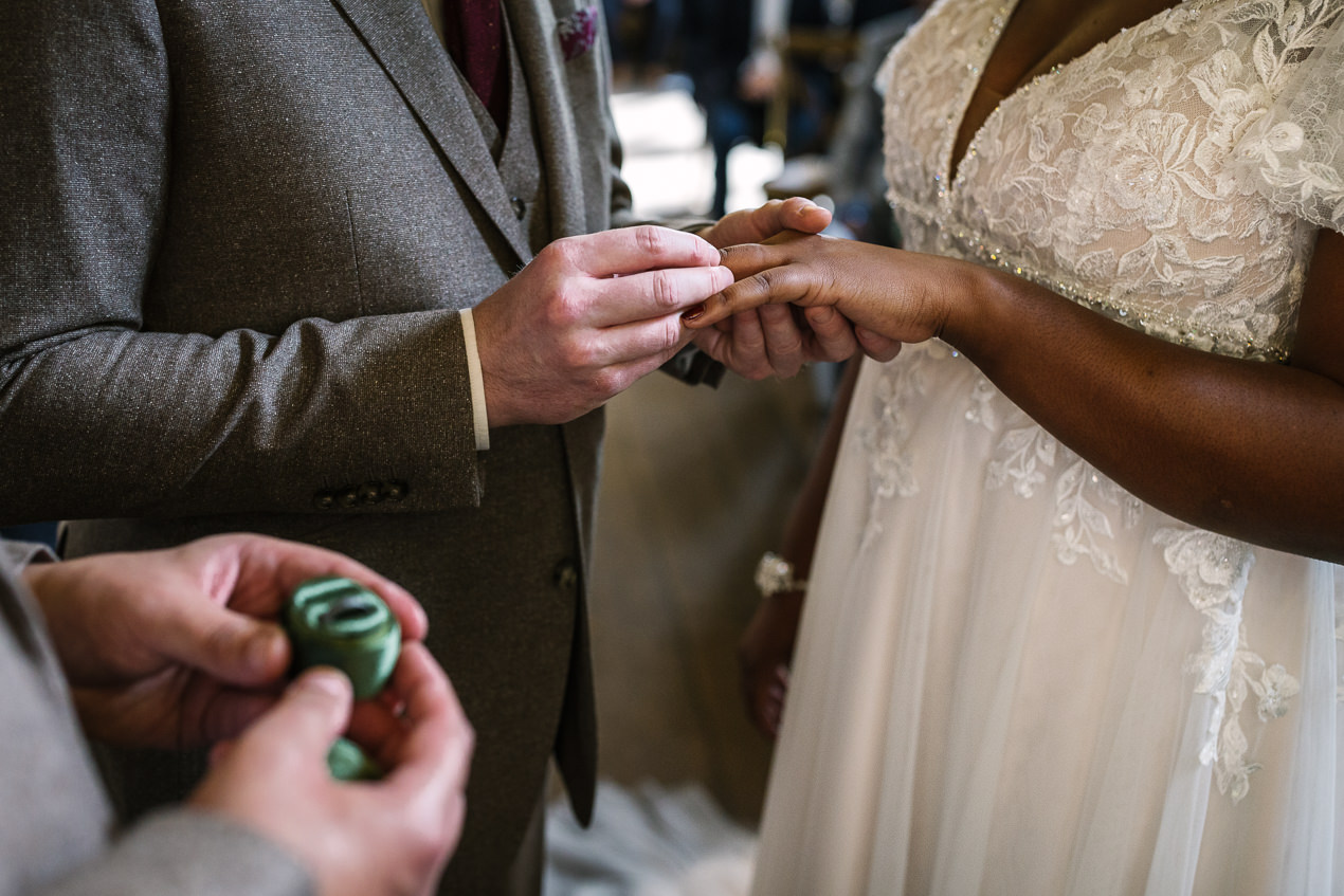wedding ring exchange during wedding ceremony at relaxed gate_street_barn wedding guildford with candid unposed natural storytelling wedding photography by documentary wedding photographer surrey sussex