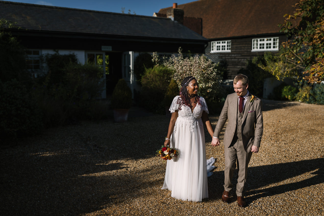 bride and groom strolling at the grounds of relaxed gate_street_barn wedding guildford with candid unposed natural storytelling wedding photography by documentary wedding photographer surrey sussex
